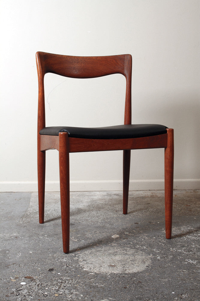 A mid century dining chair in solid Teak by Arne Vodder for Vamo Sønderborg. A sculptural, curved backrest and with a black vinyl seat.
