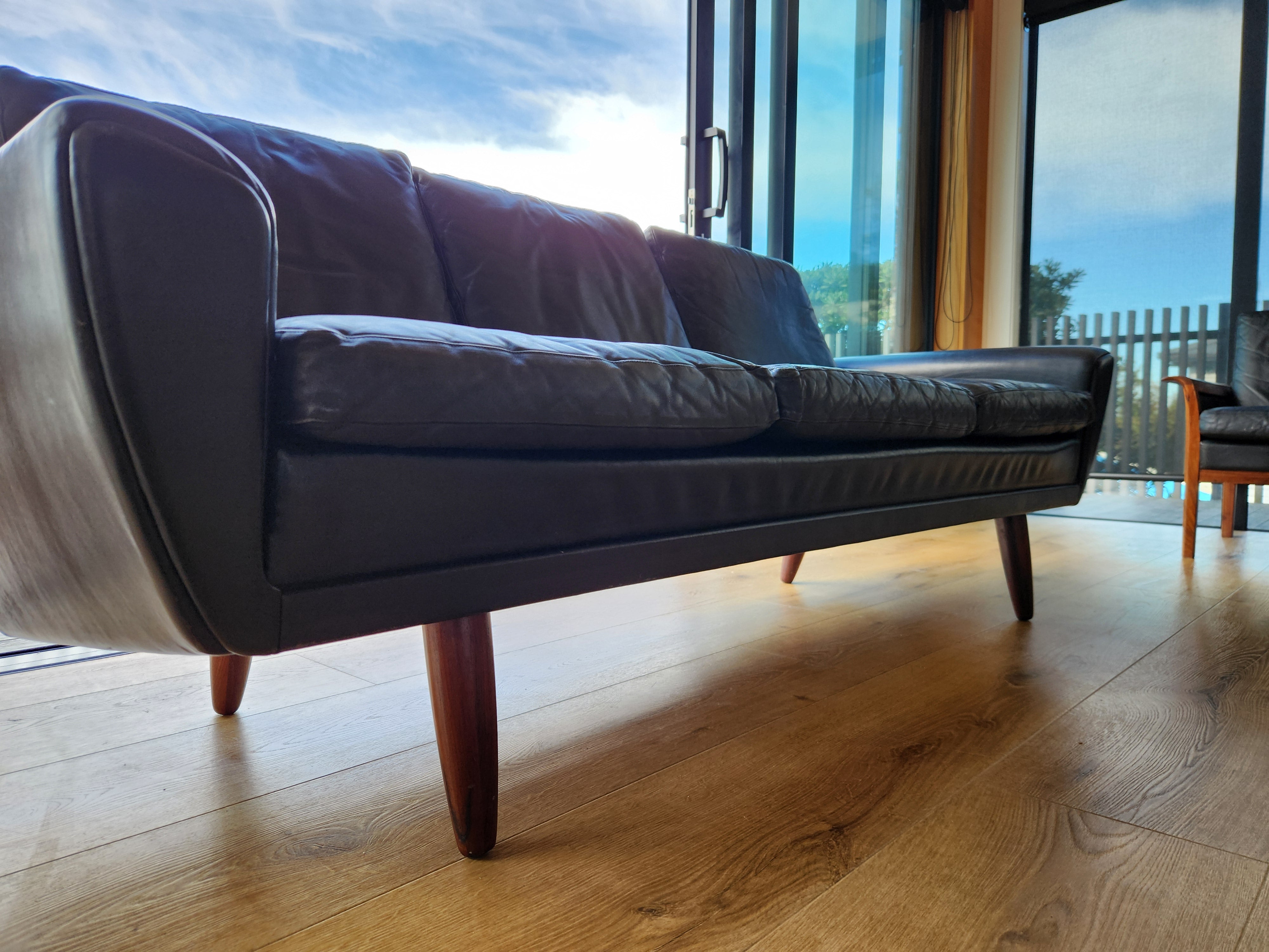 Danish mid century sofa. Close up of side view from front left.