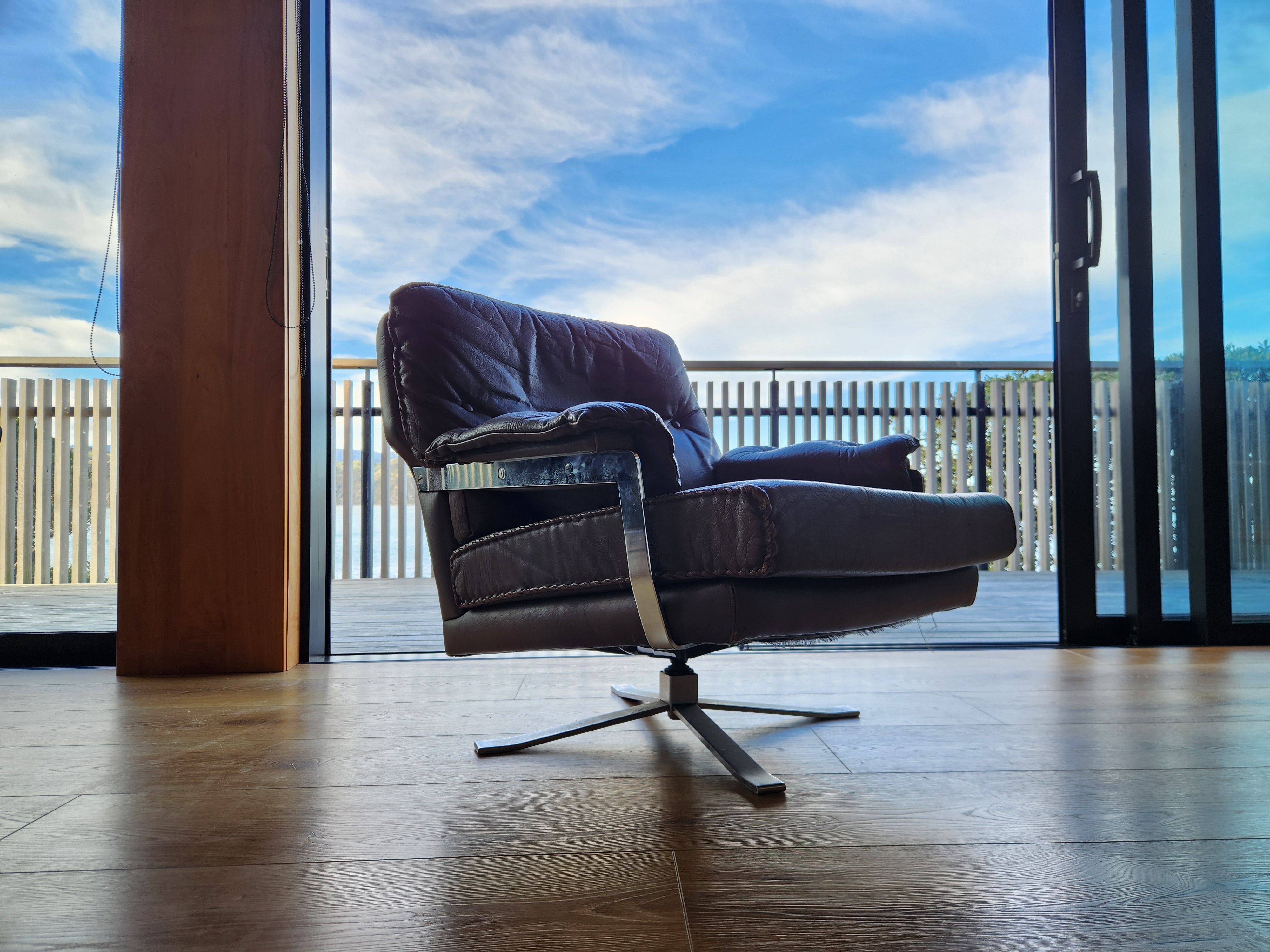 Mid Century Danish Swivel Armchair by Arne Norell. With brown handstitched leather and chrome base.