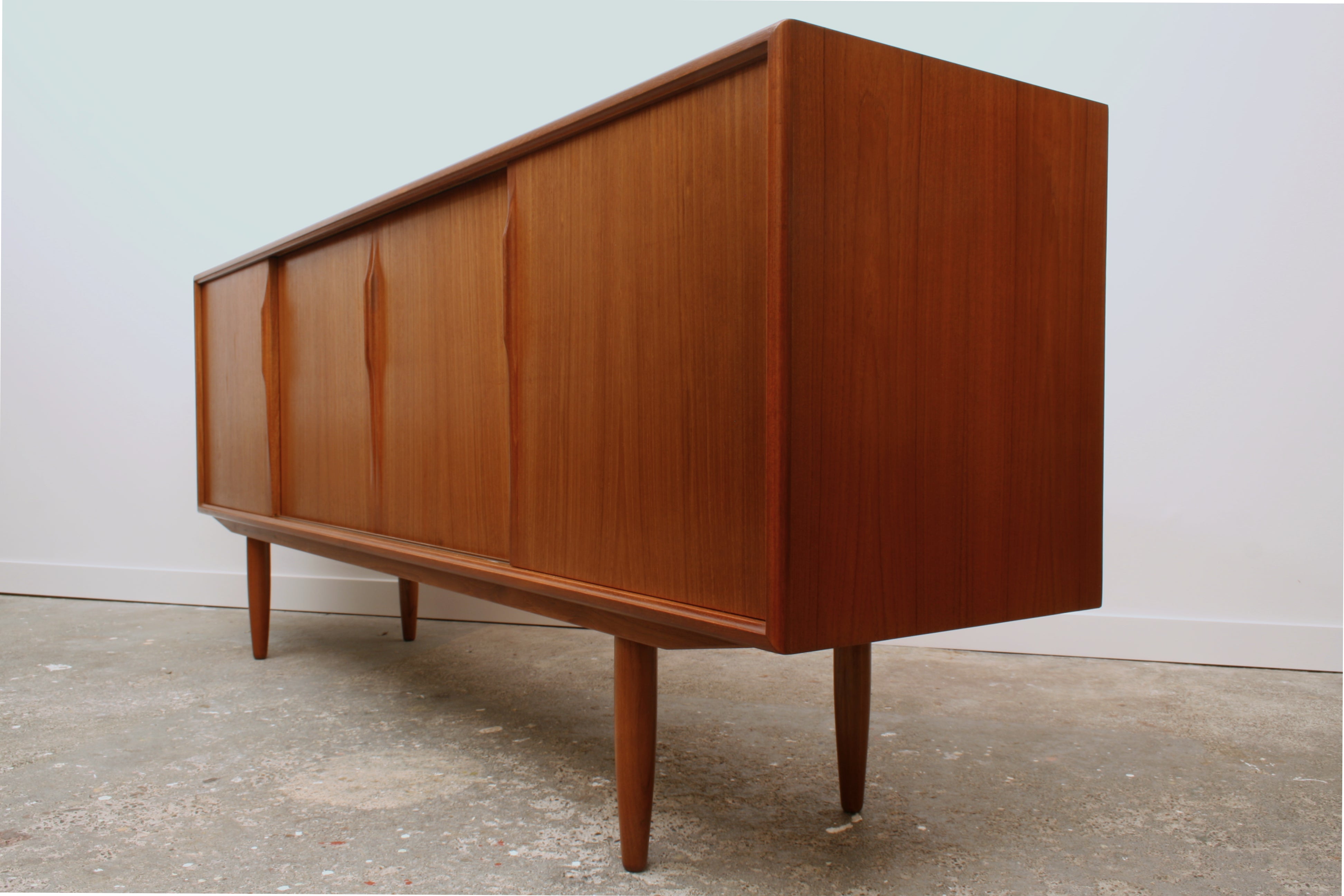 Mid century sideboard from isometric view highlighting sleek door handle profile.
