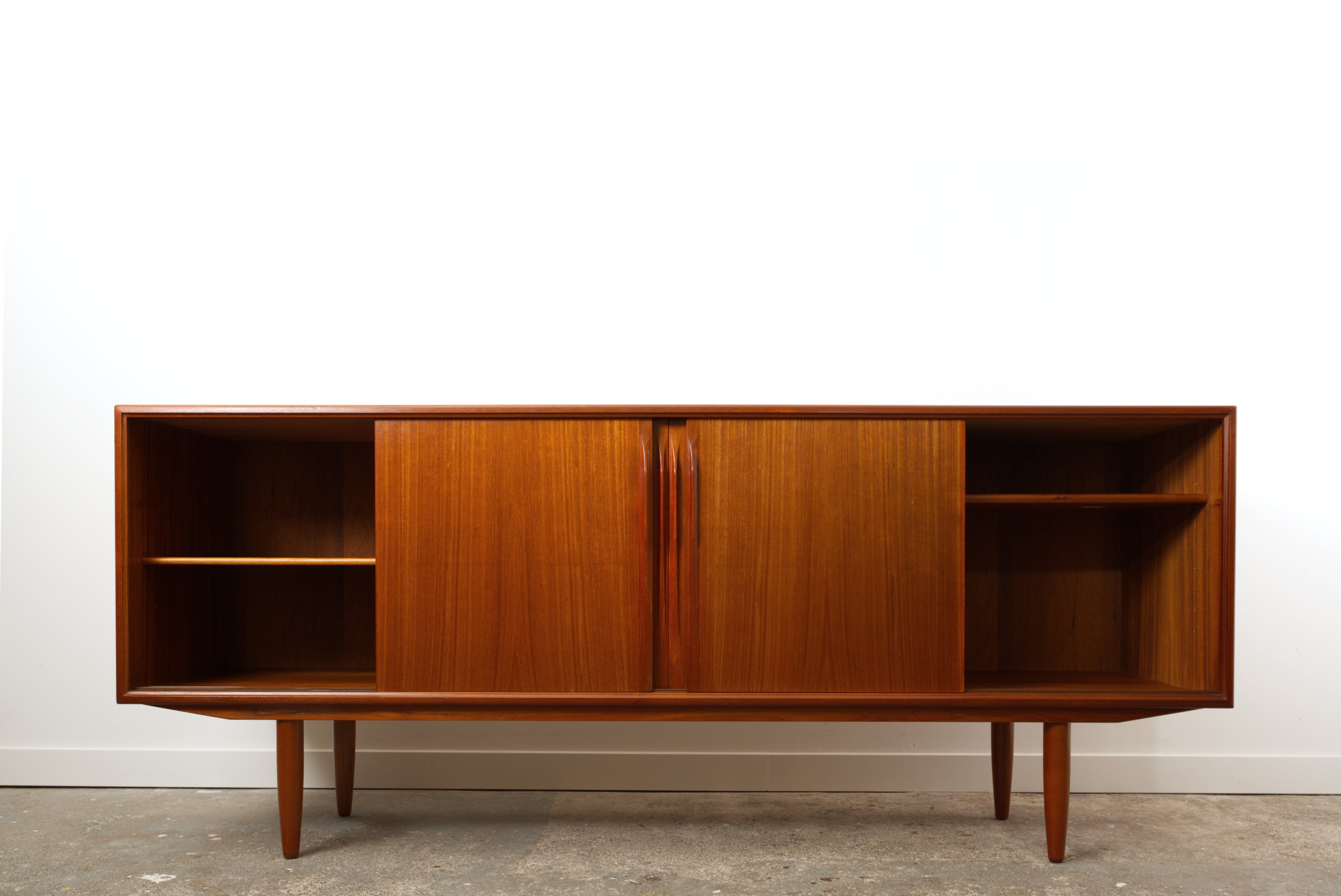 Danish Teak mid century sideboard with its two outer doors slid to the centre.
