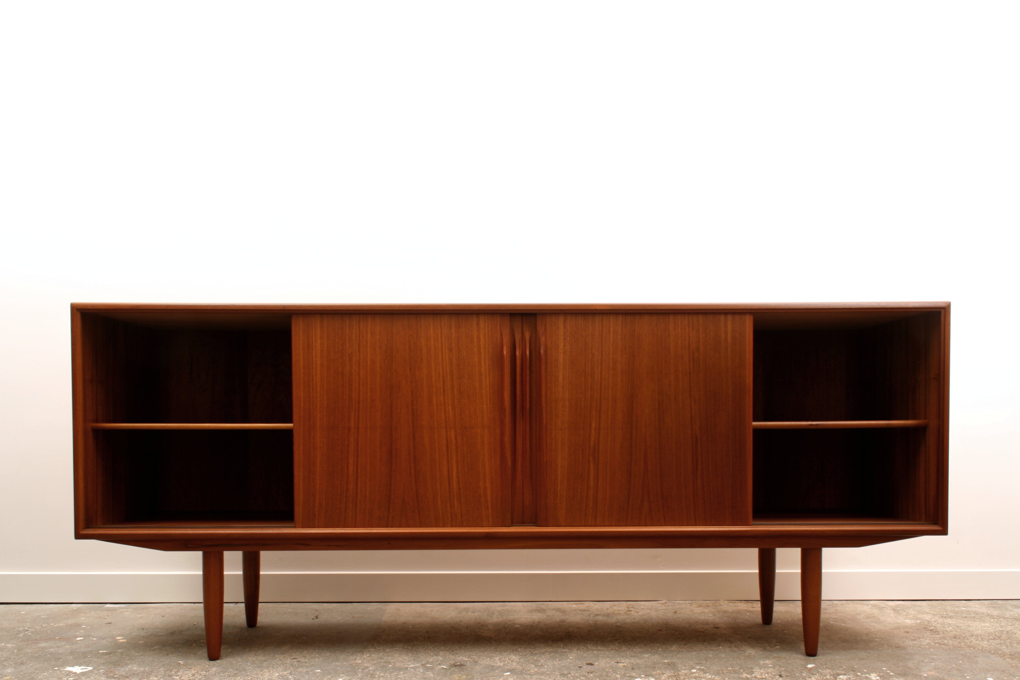 Danish Teak mid century sideboard with its two outer doors slid to the centre.