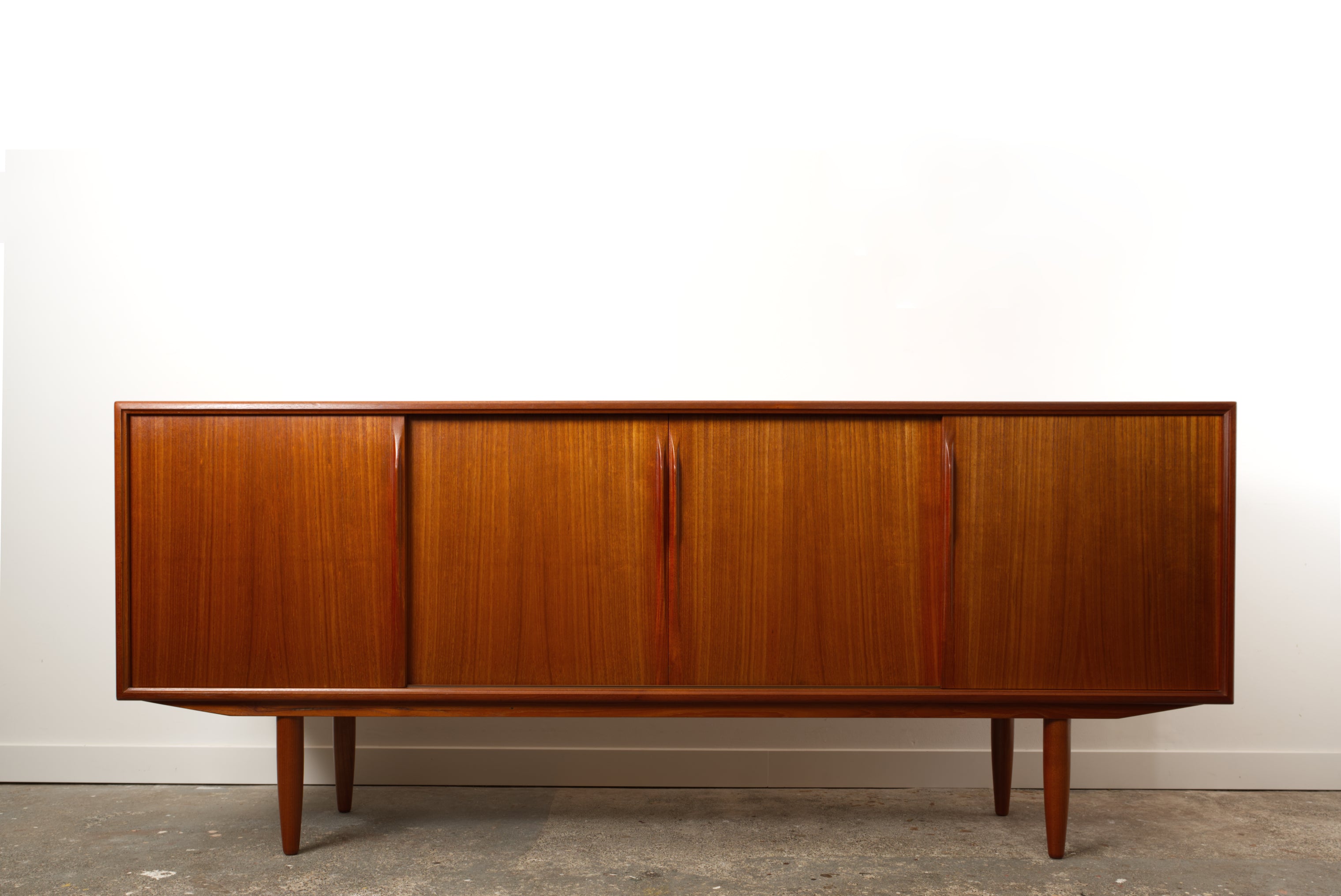 Danish Teak mid century sideboard by ACO Møbler with minimalist detailing and four sliding doors.