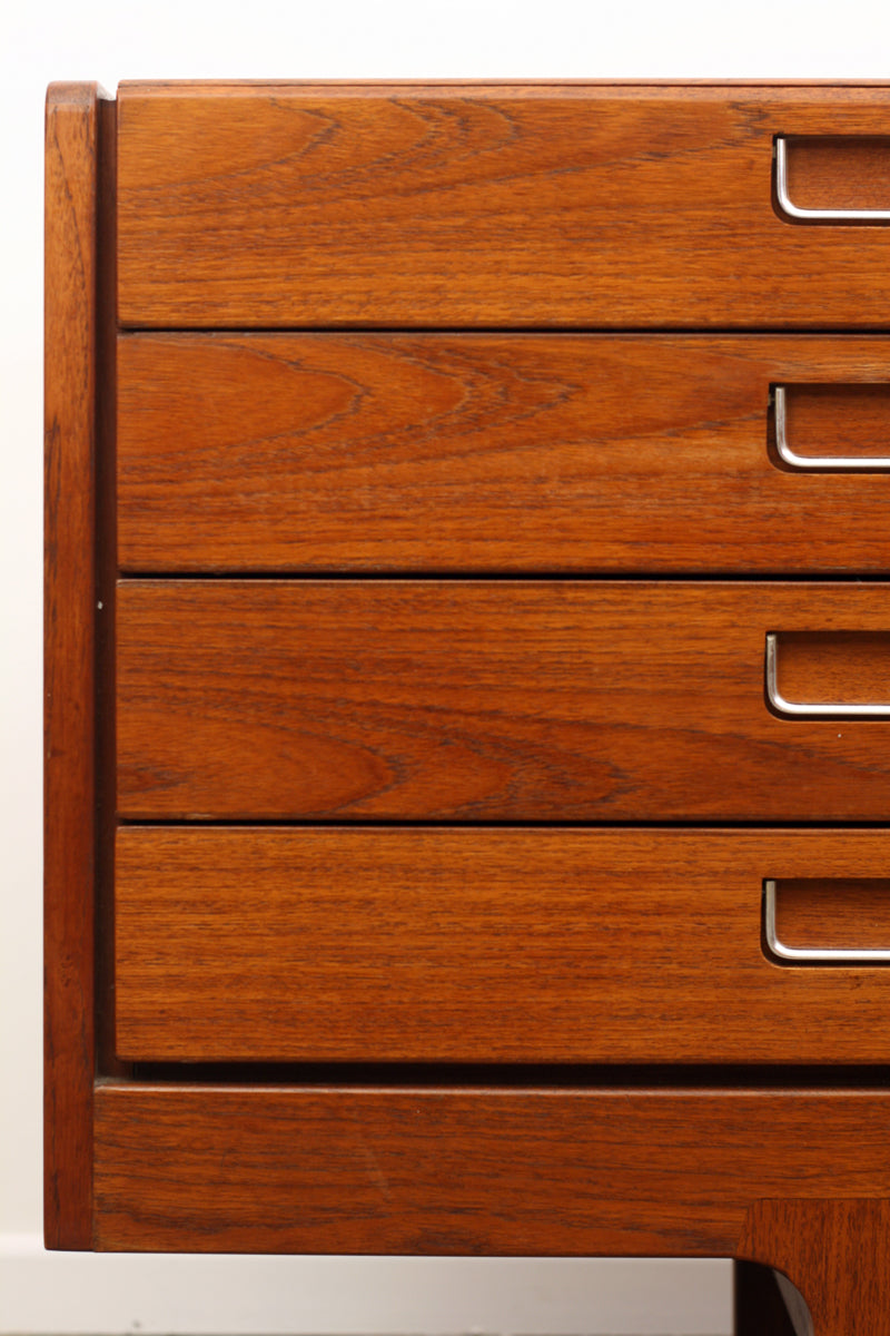A close up of a mid century sideboard by Meredew in Teak. Showing the left side bank of four drawers with military-esque inset metal handles.