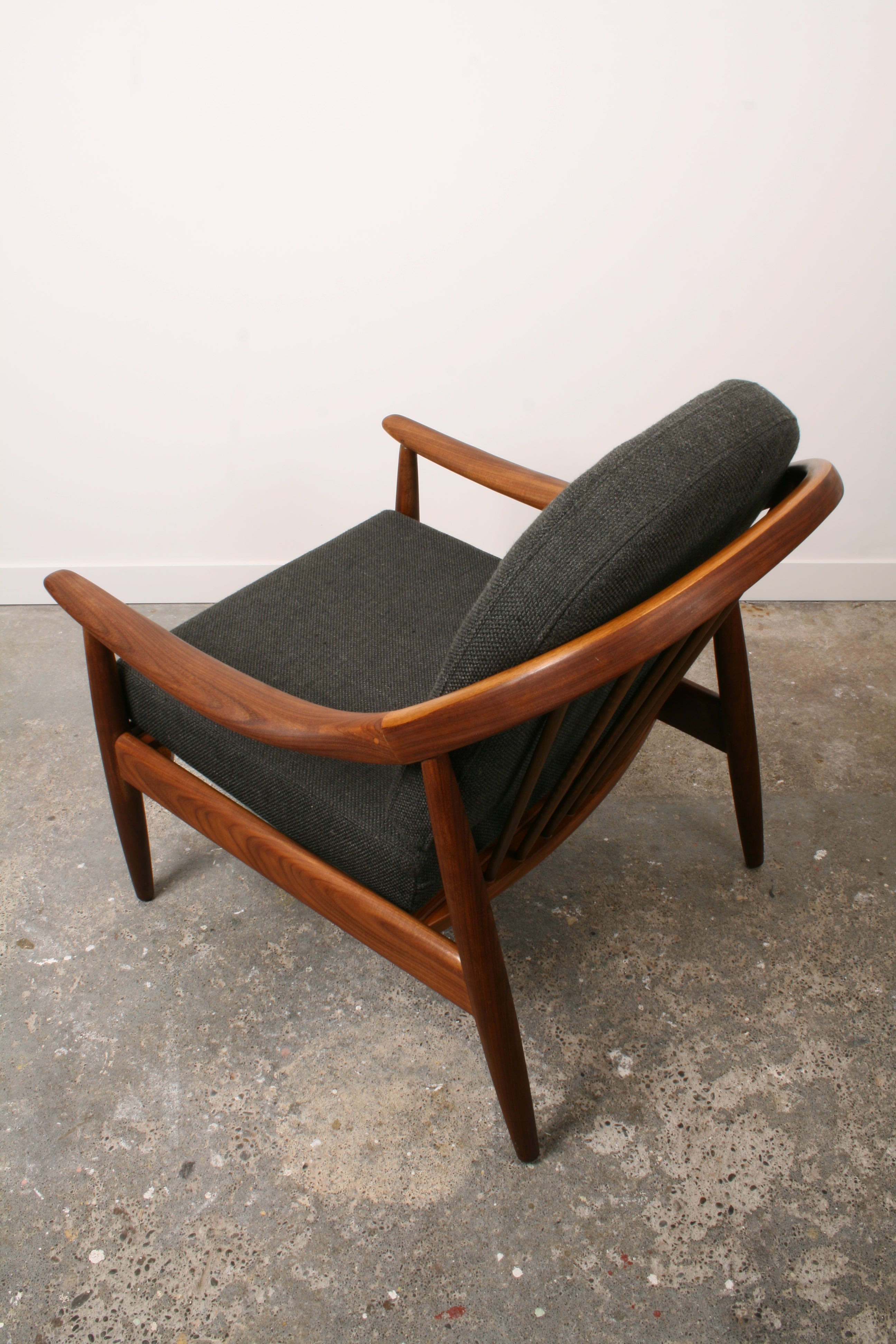 Mid Century Teak armchair from above and towards rear of chair highlighting the curved back rest.