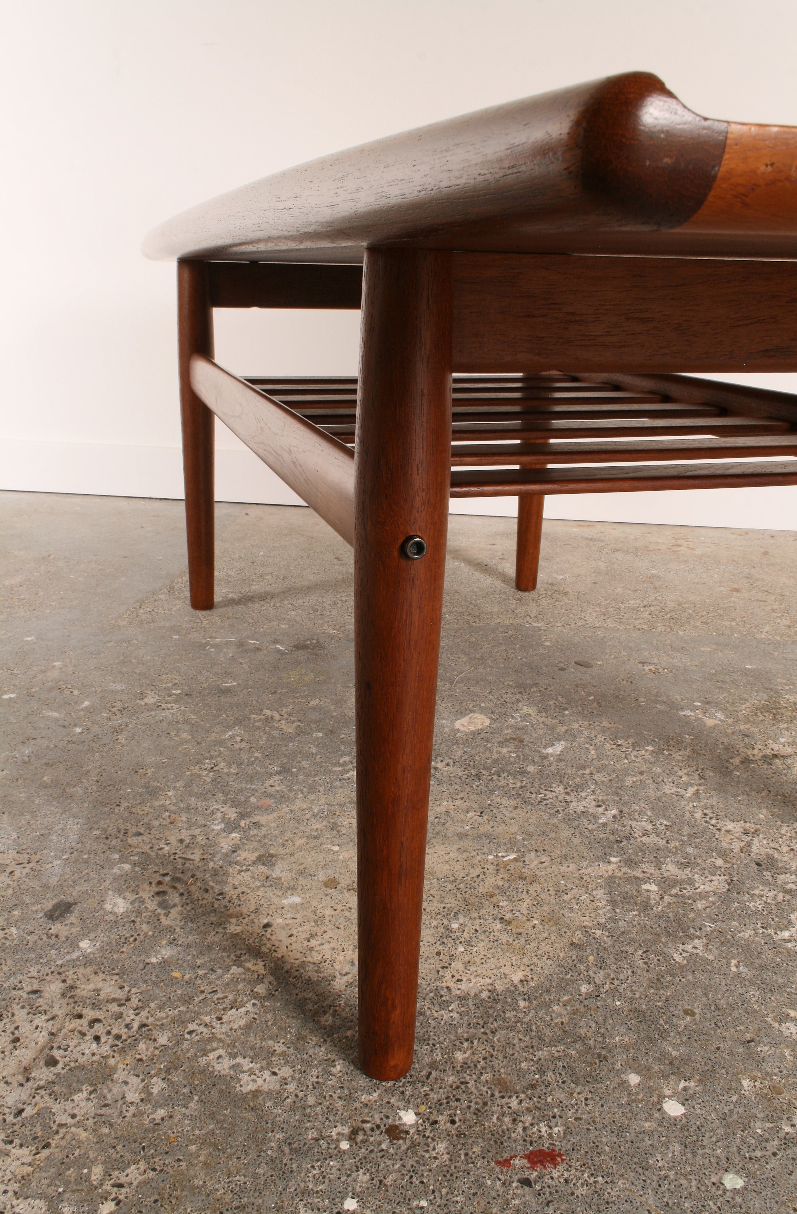 Mid Century Danish Teak Coffee Table.  Leg and magazine shelf detail. Also detailing the solid teak, curved, moulded edge to top.