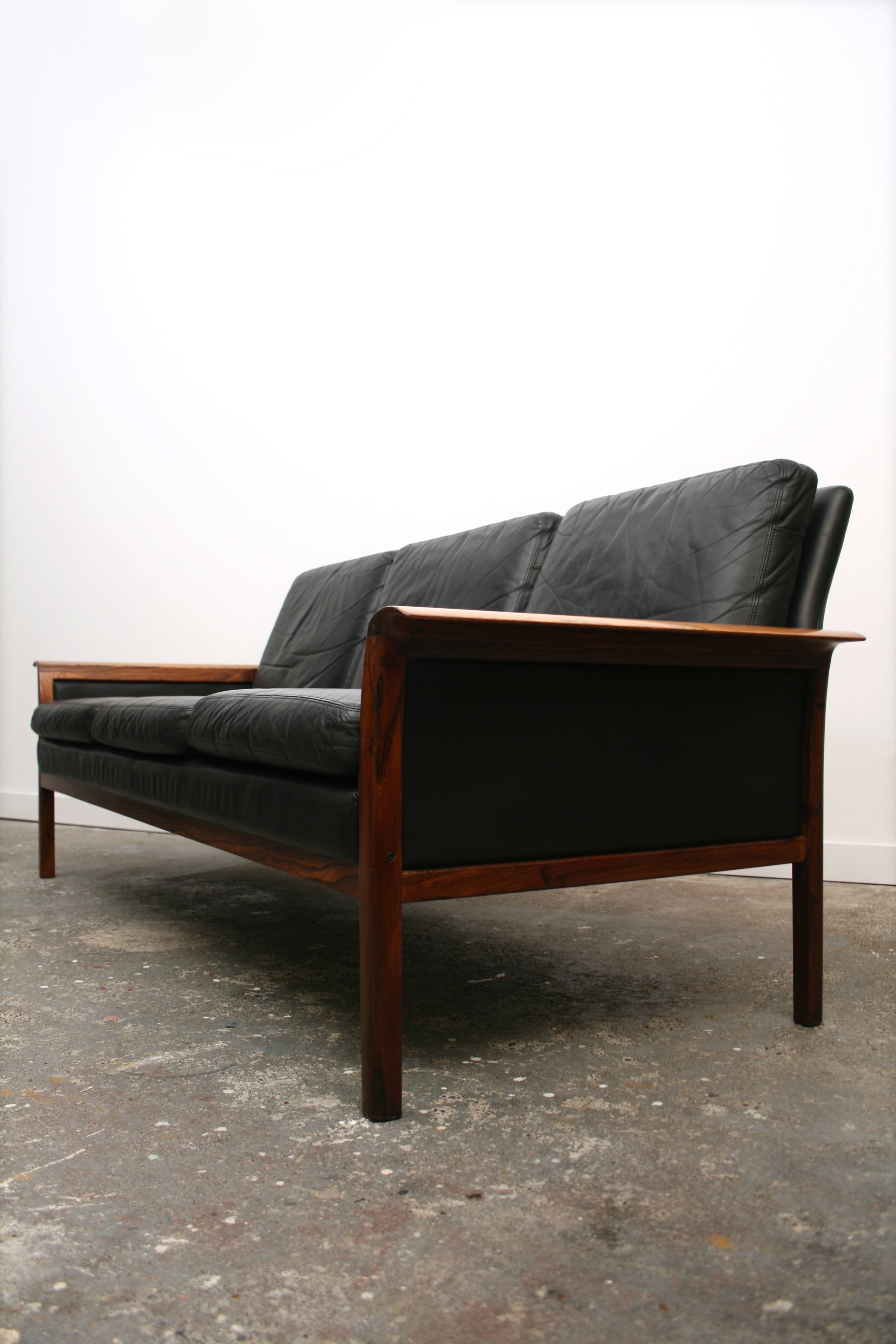 Mid Century Sofa.Colouful Rosewood legs and armrest with inset black leather panel.