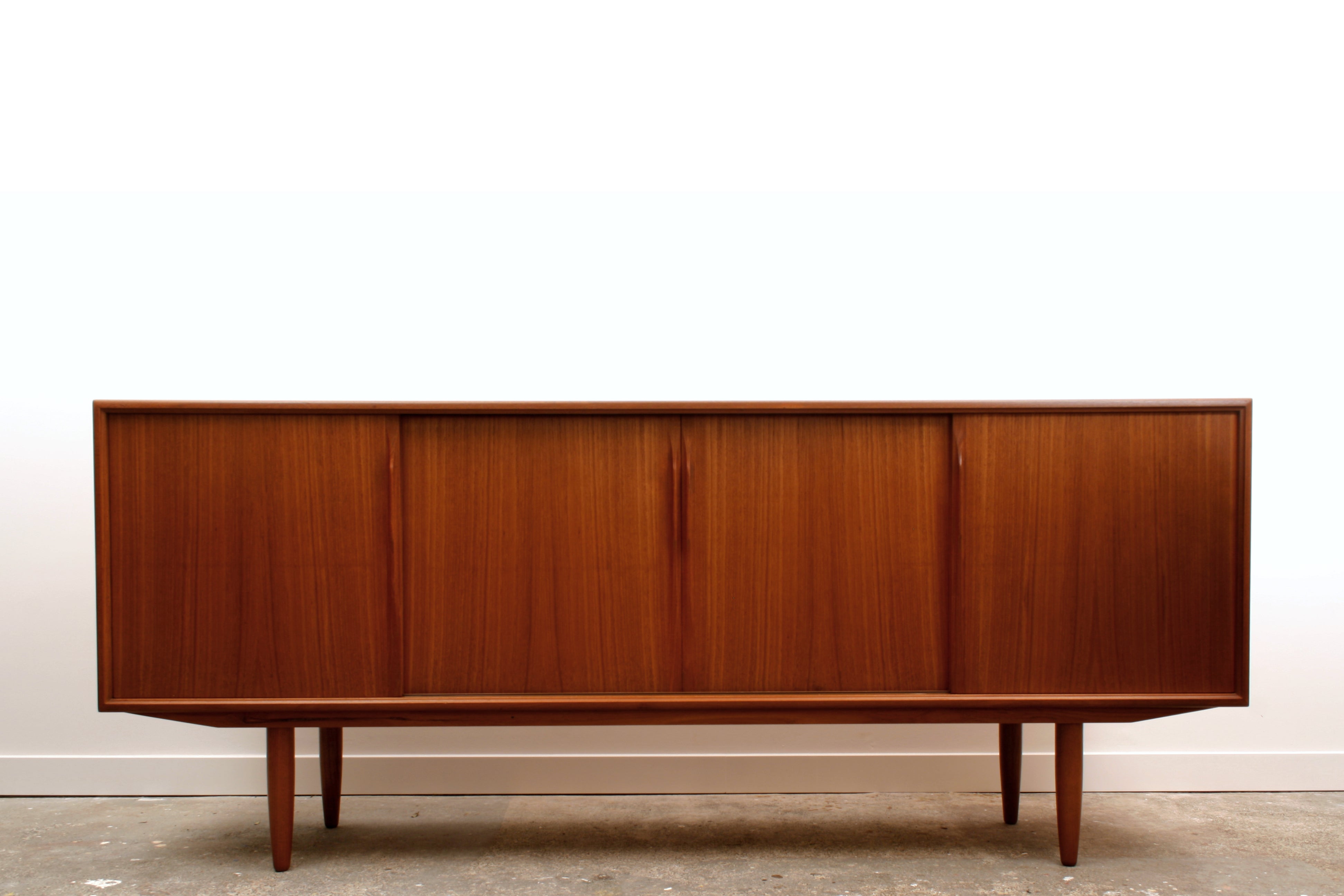 Danish Teak mid century sideboard by ACO Møbler with minimalist detailing and four sliding doors.