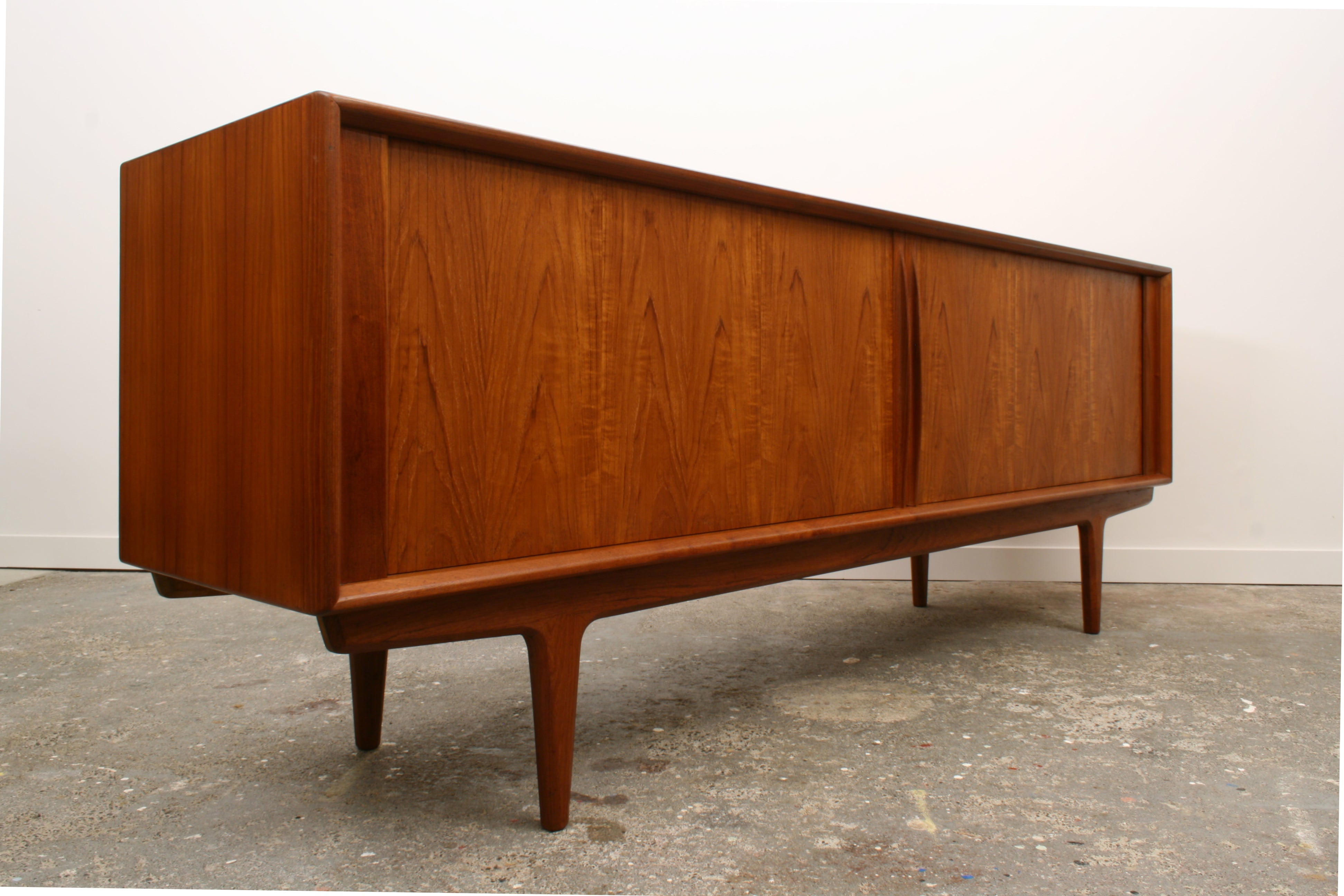 Danish Teak Tambour with shadows highlighting its minimalist appeal.