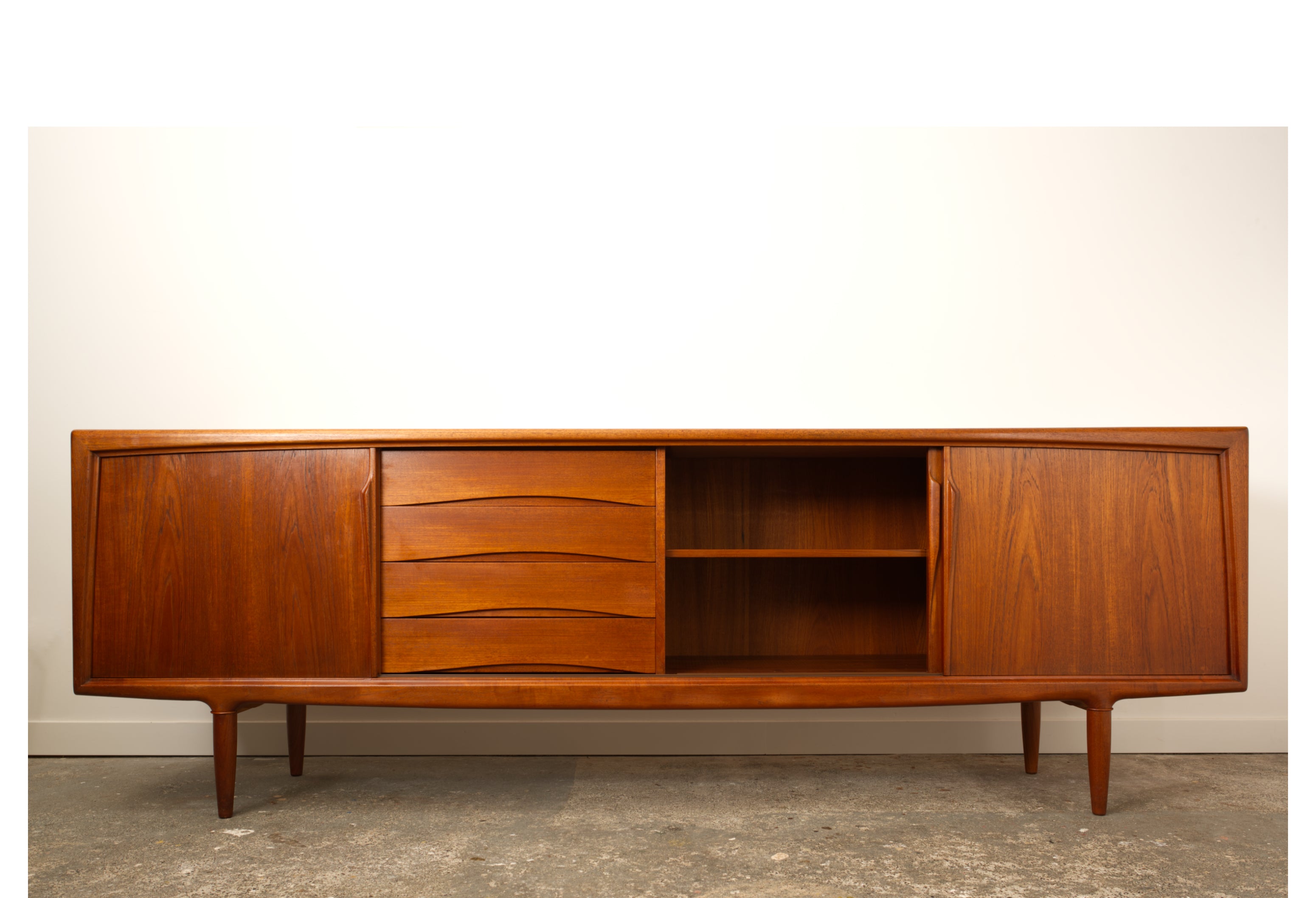 Teak Danish sideboard by Gunni Omann. Seen from the front with central door slid open.