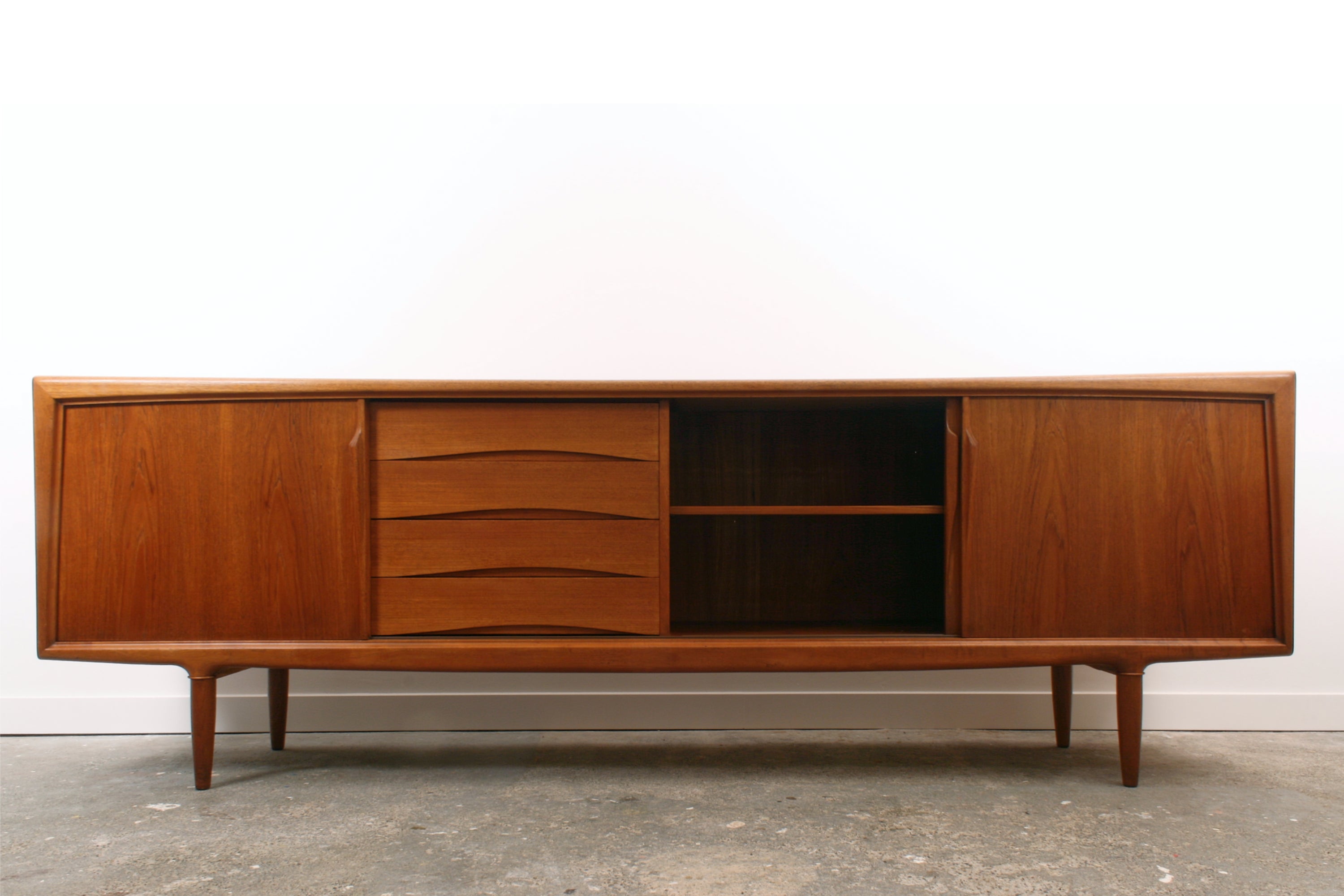 Teak Danish sideboard by Gunni Omann. Seen from the front with central door slid open.