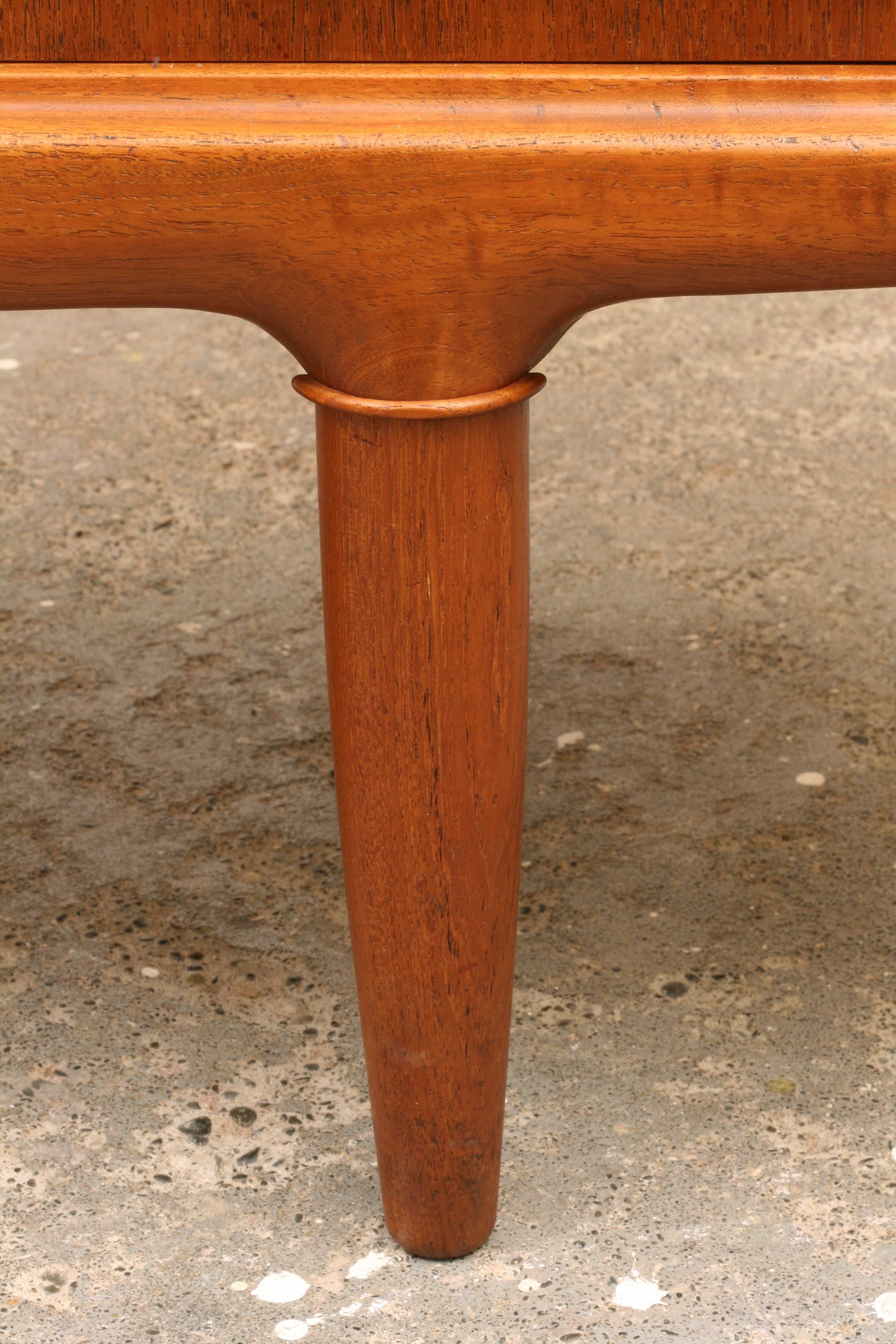 Danish teak sideboard close up of tapered leg and moulding detail.