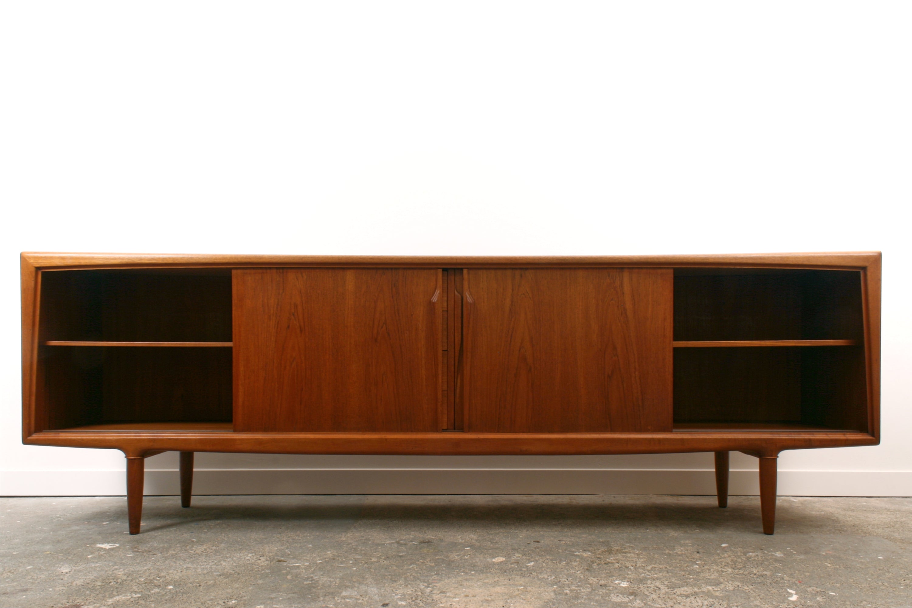 Teak Danish sideboard by Gunni Omann. Seen from the front with the outer doorsslid open.