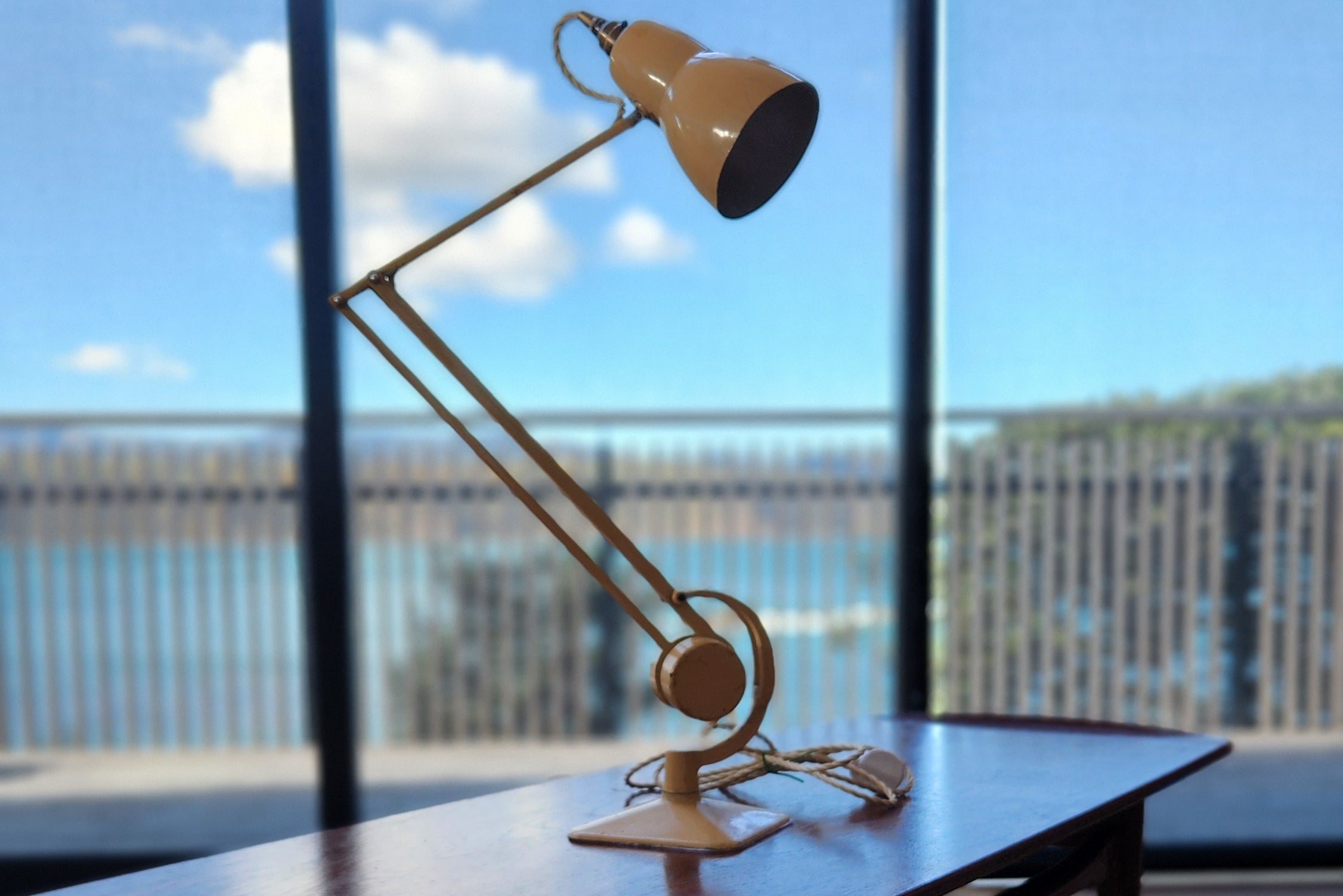 Hadrill Horstmann counterbalanced Mid Century Anglepoise lamp in cream. Blue sky background.