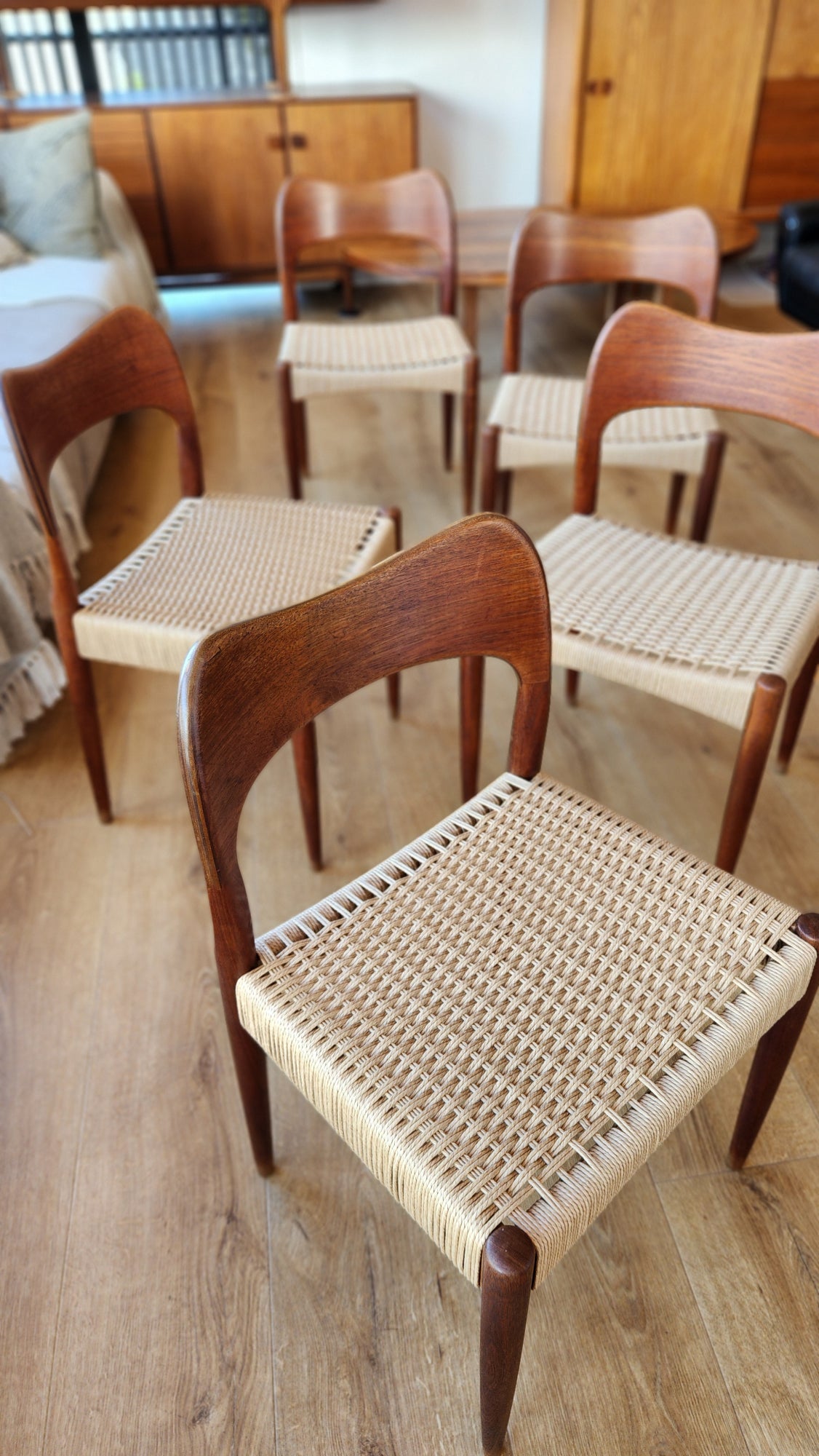 A set of eight Arne Hovmand-Olsen chairs by Mogens Kold (five shown). With newly weaved Danish cord. Sideboards in background.