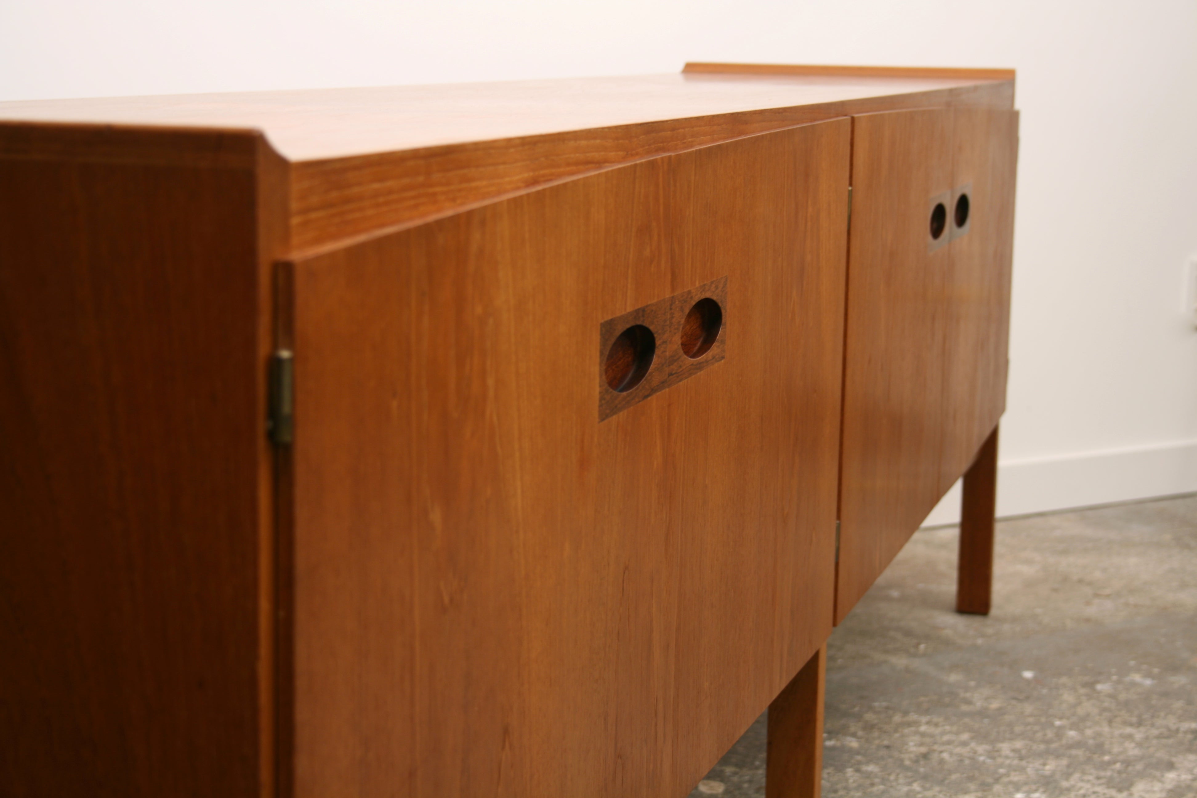 Mid Century sideboard with flowing curve running length of the top and bottom of doors.