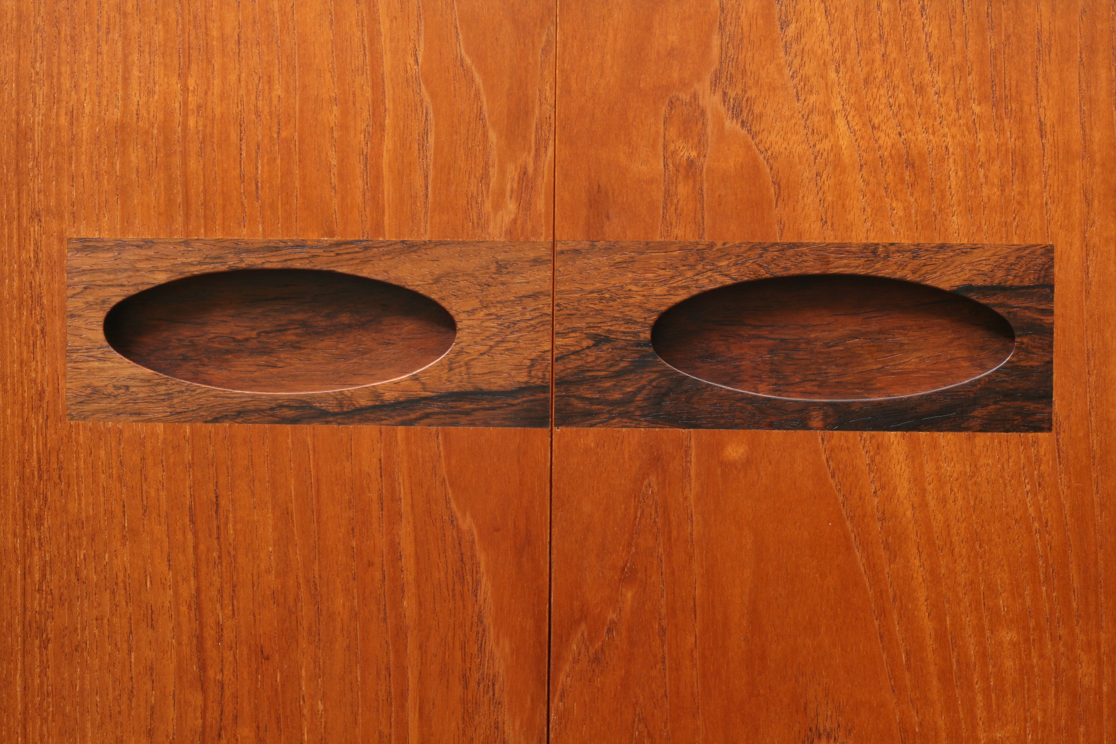 mid century sideboard close-up of Inset solid rosewood handles of ovoid recessed pull design.