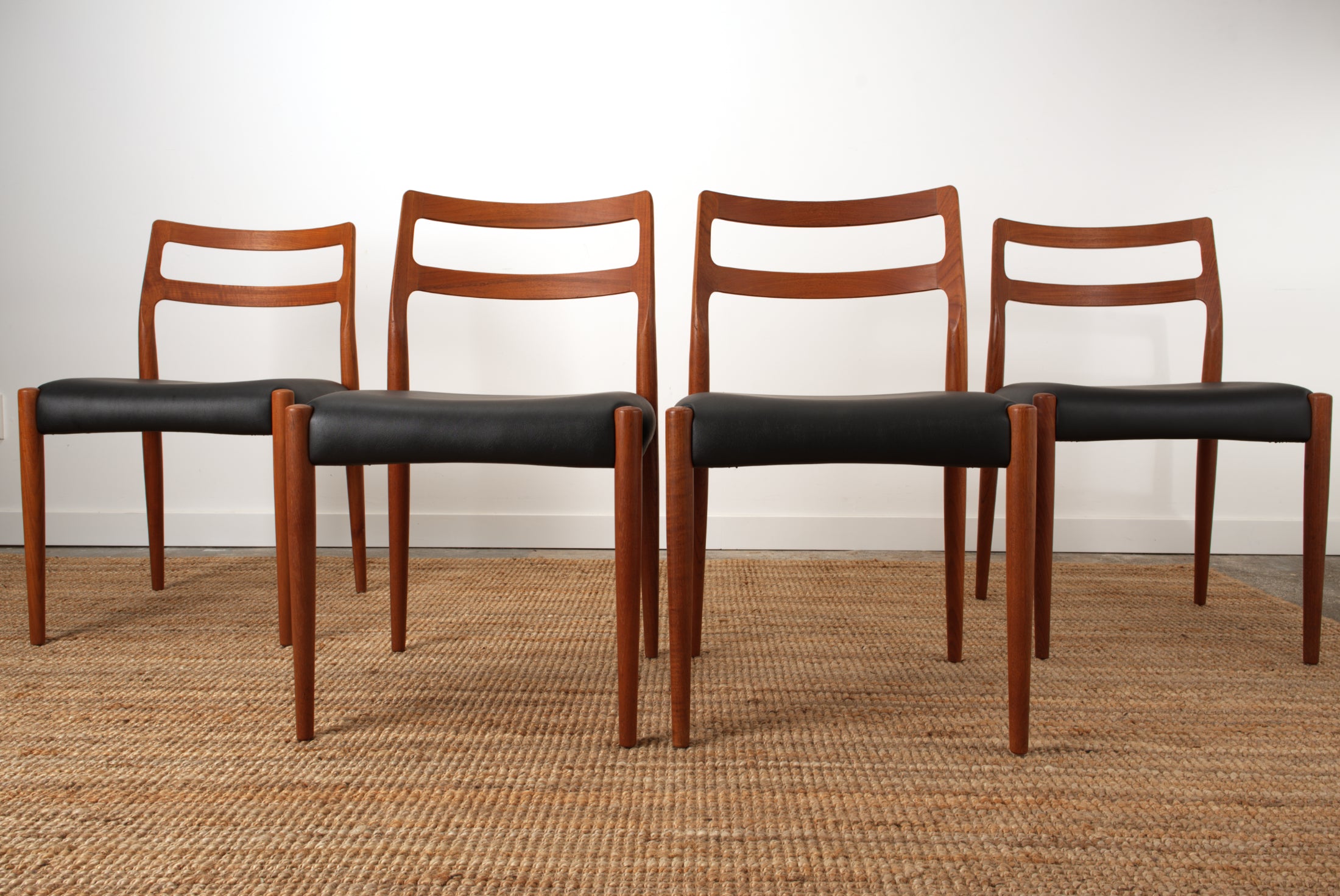 Four Johannes Andersen 'Anne' chairs in a line.