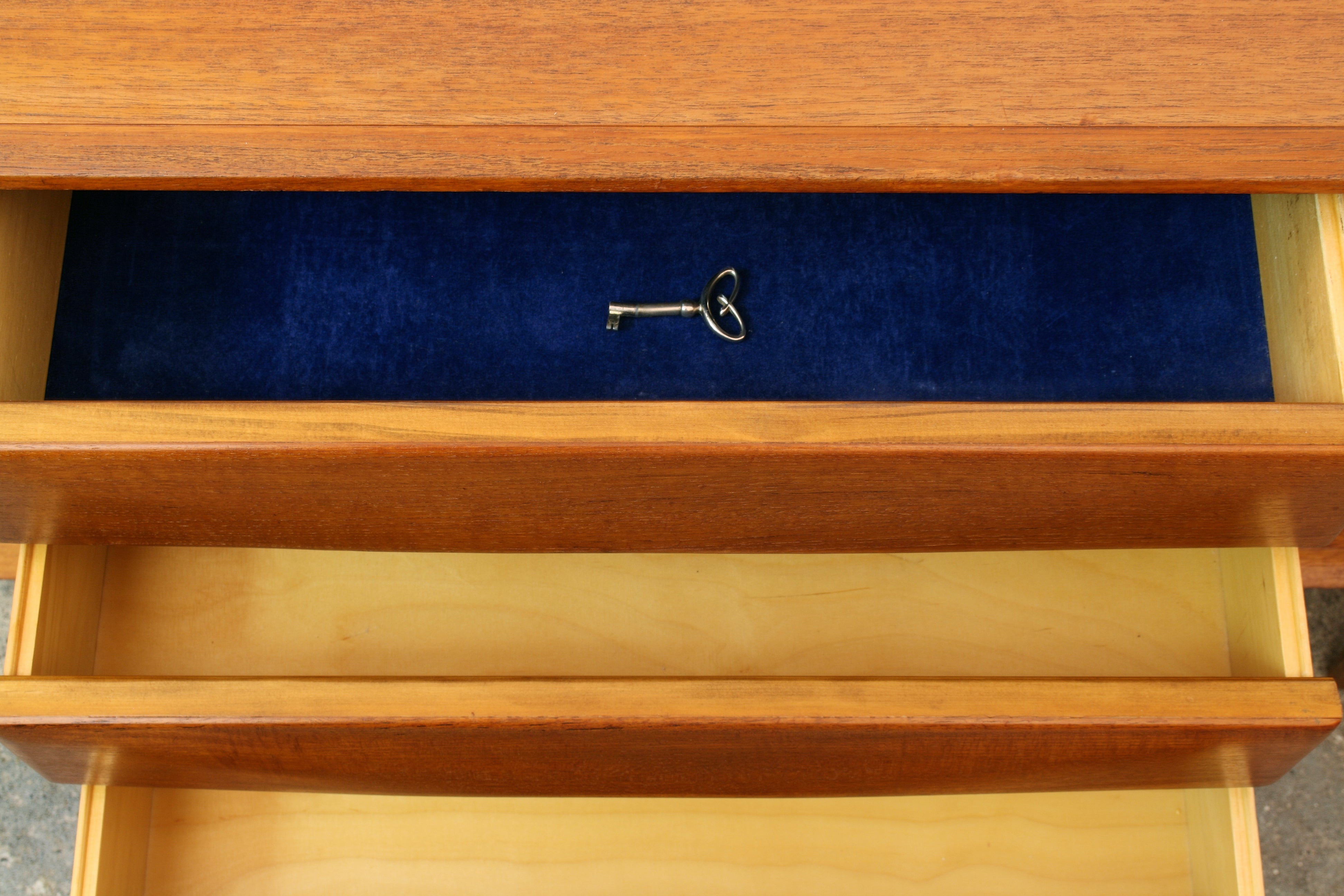 Norwegian teak sideboard closeup of purple velvet lined top drawer with cabinet key inside.