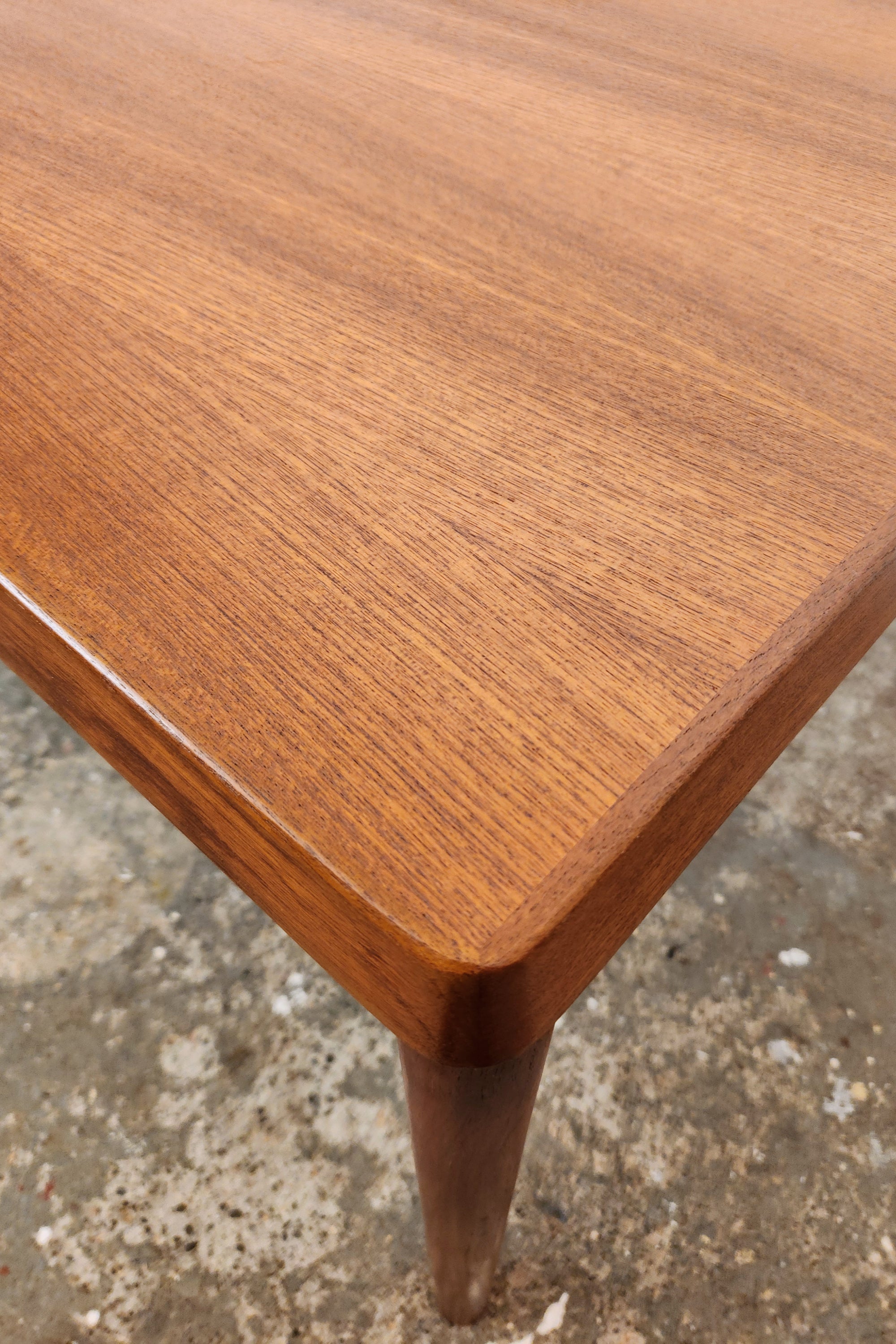 Henning Kjaernulf Danish Dining Table. Viewed from above over a corner. Detailing the curved and gently angled profile of the top edge.