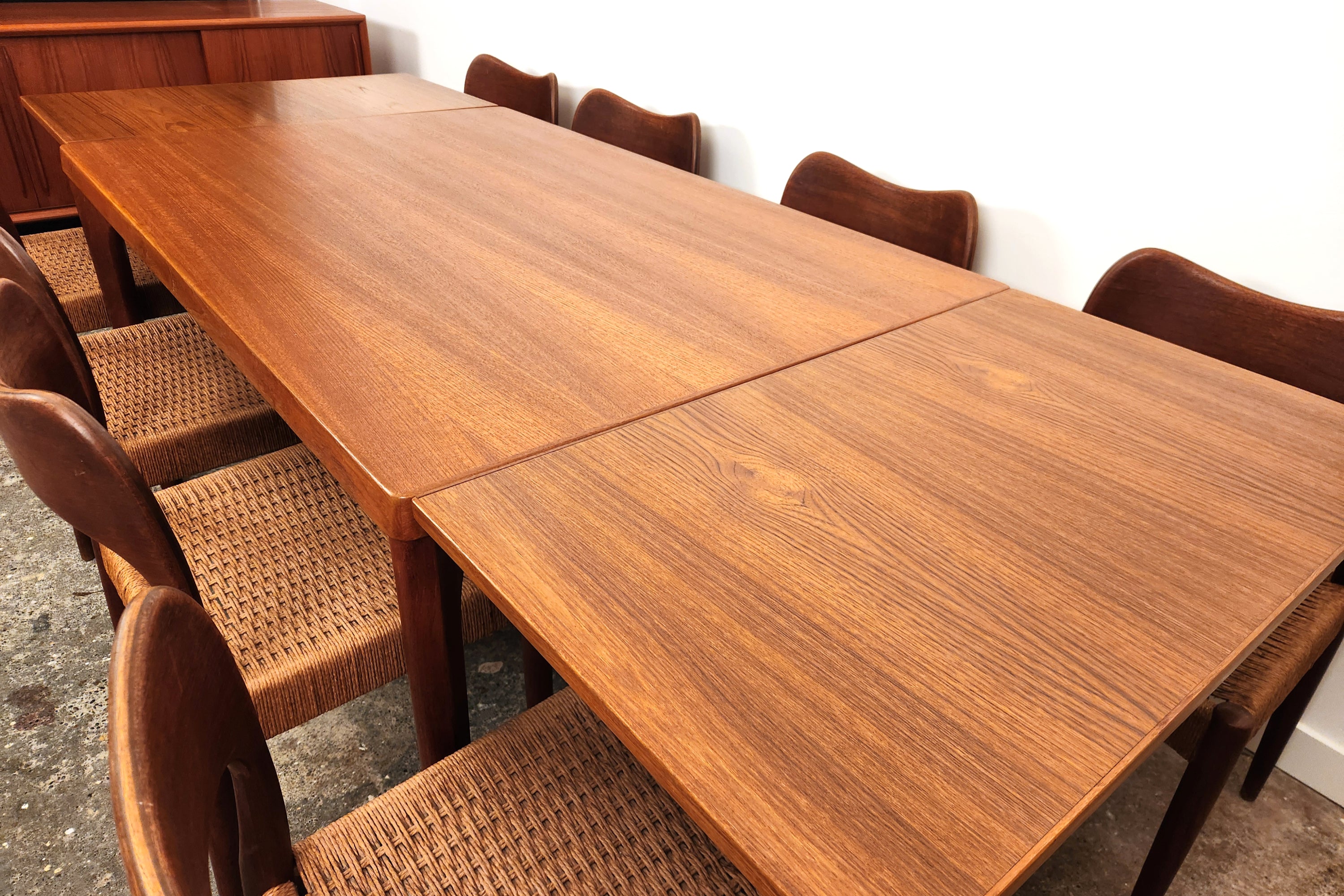 Henning Kjaernulf Danish Dining Table. Fully extended. With eight chairs. From an angle from right corner.