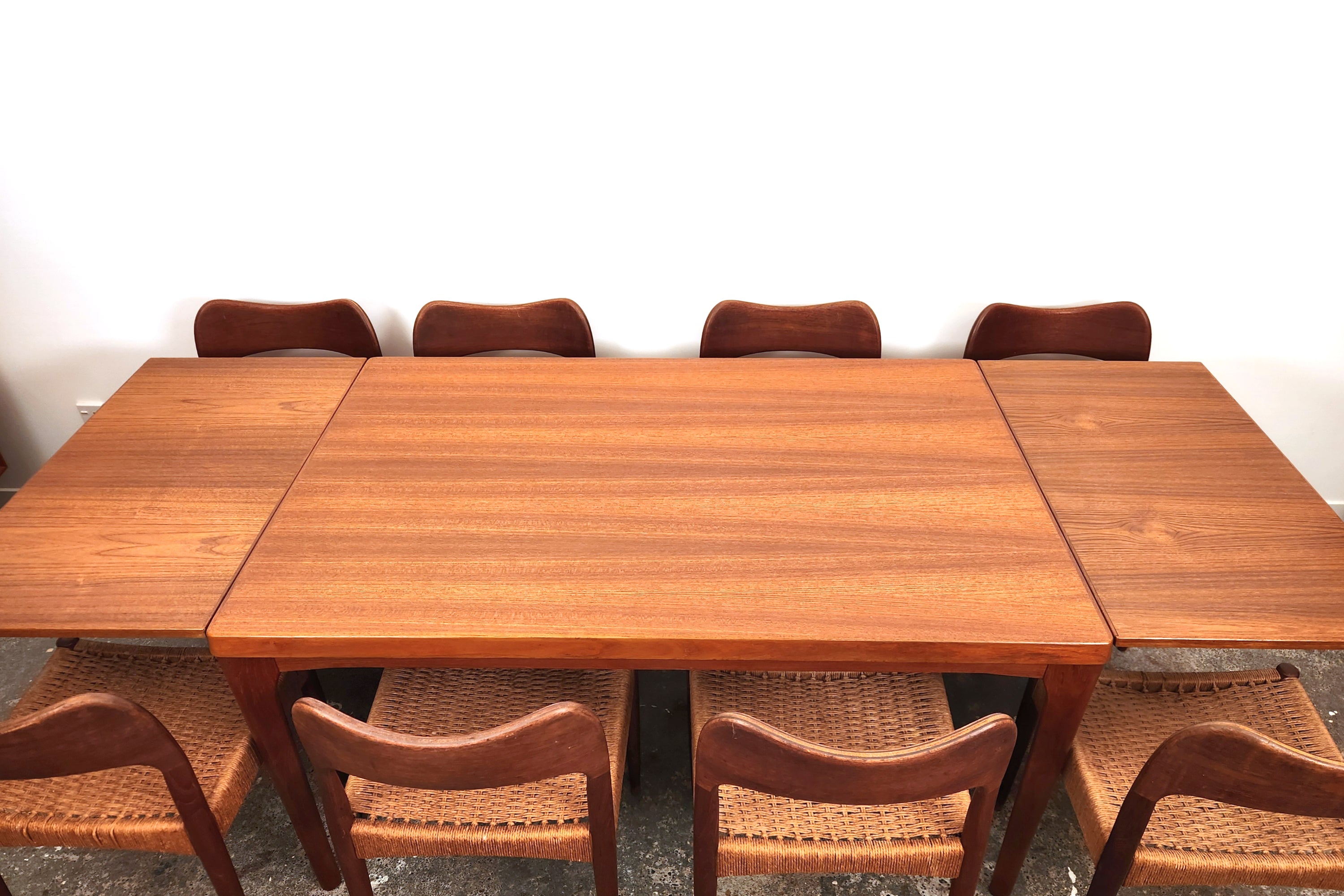Henning Kjaernulf Danish Dining Table. Fully extended. With eight chairs. Viewed along the table length.