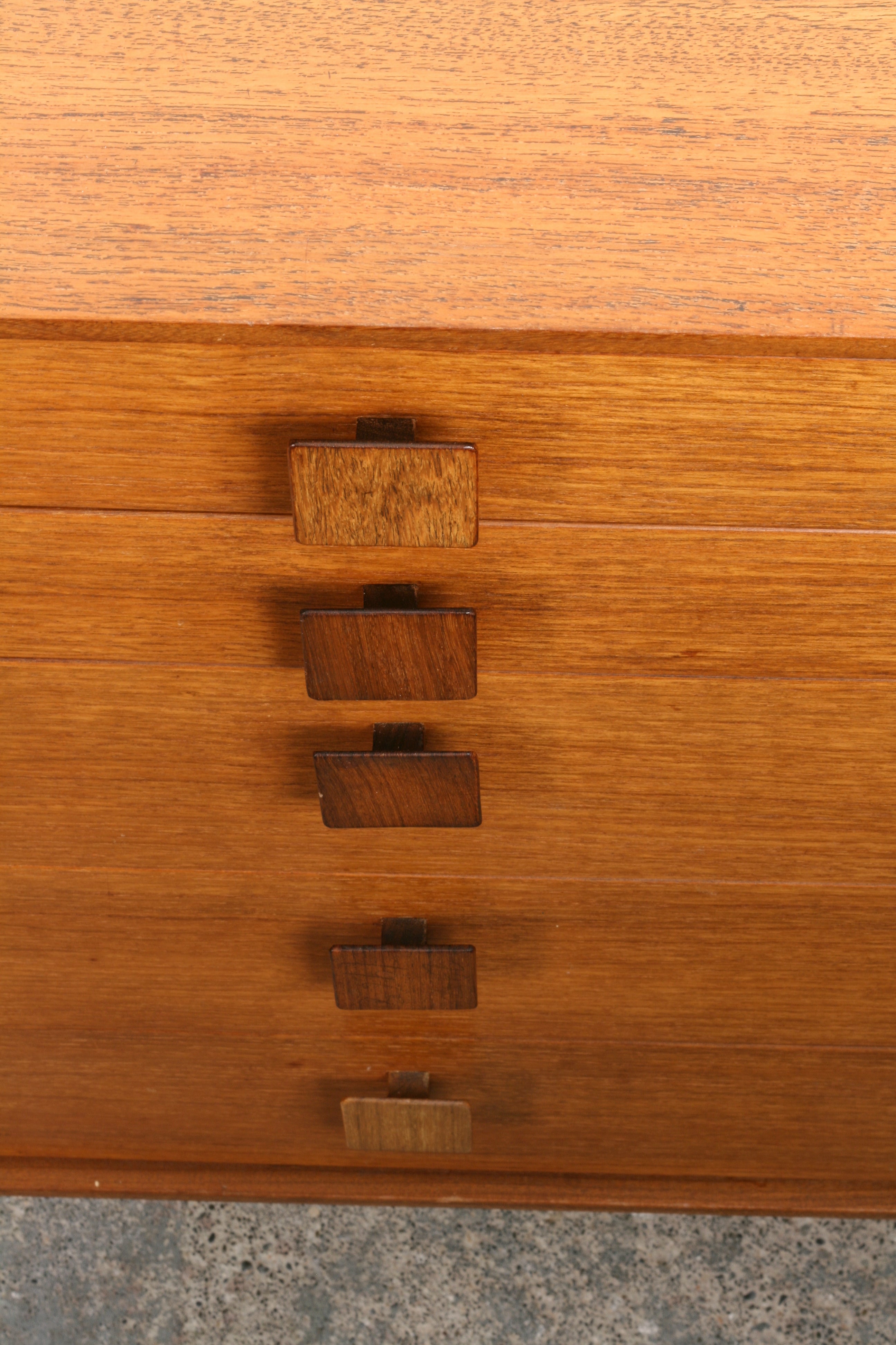 Mid Century teak sideboard looking down on the row of rosewood drawer handles.