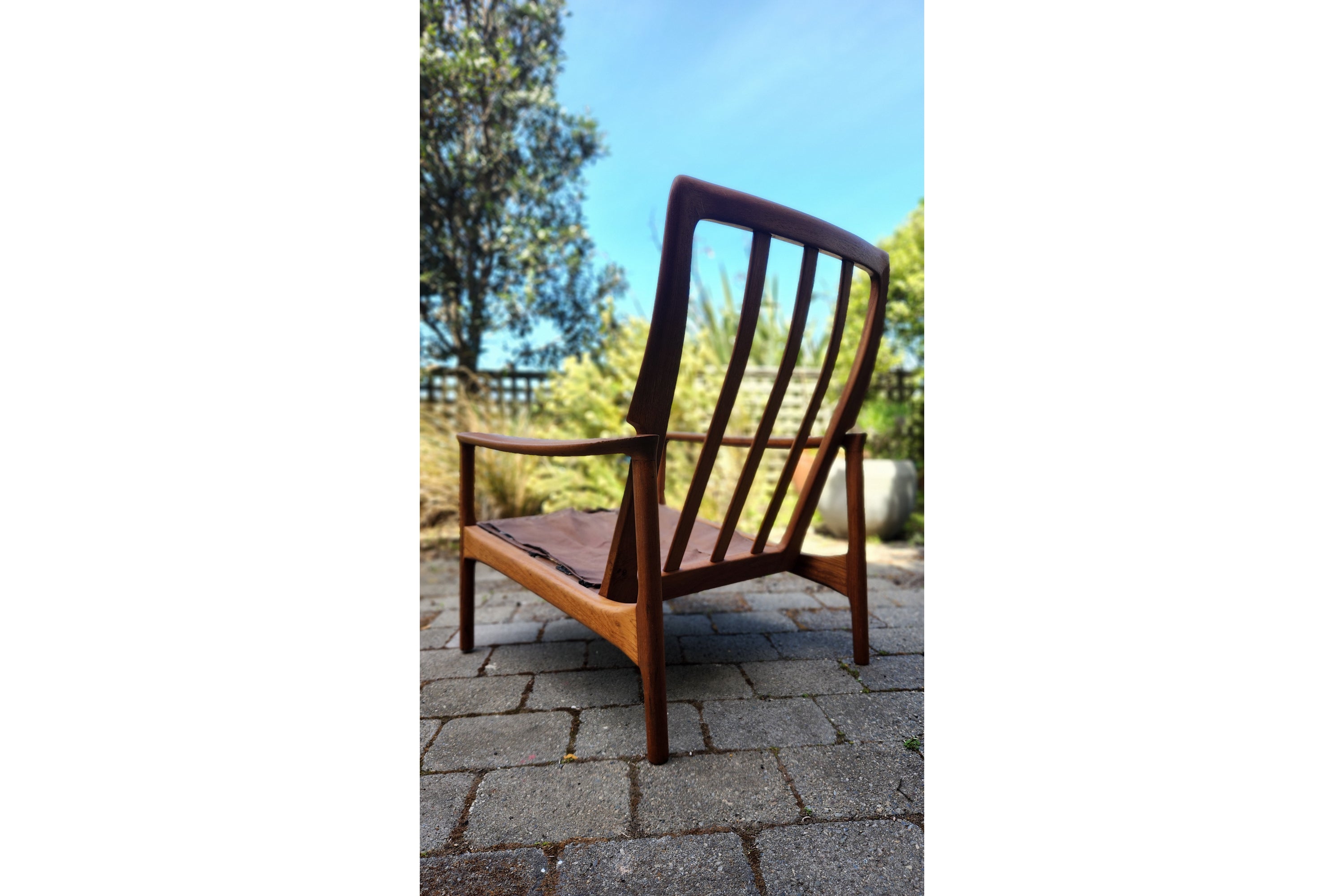 German Mid Century armchair by Mann Mobel in Teak. Seen in sleek profile from rear.