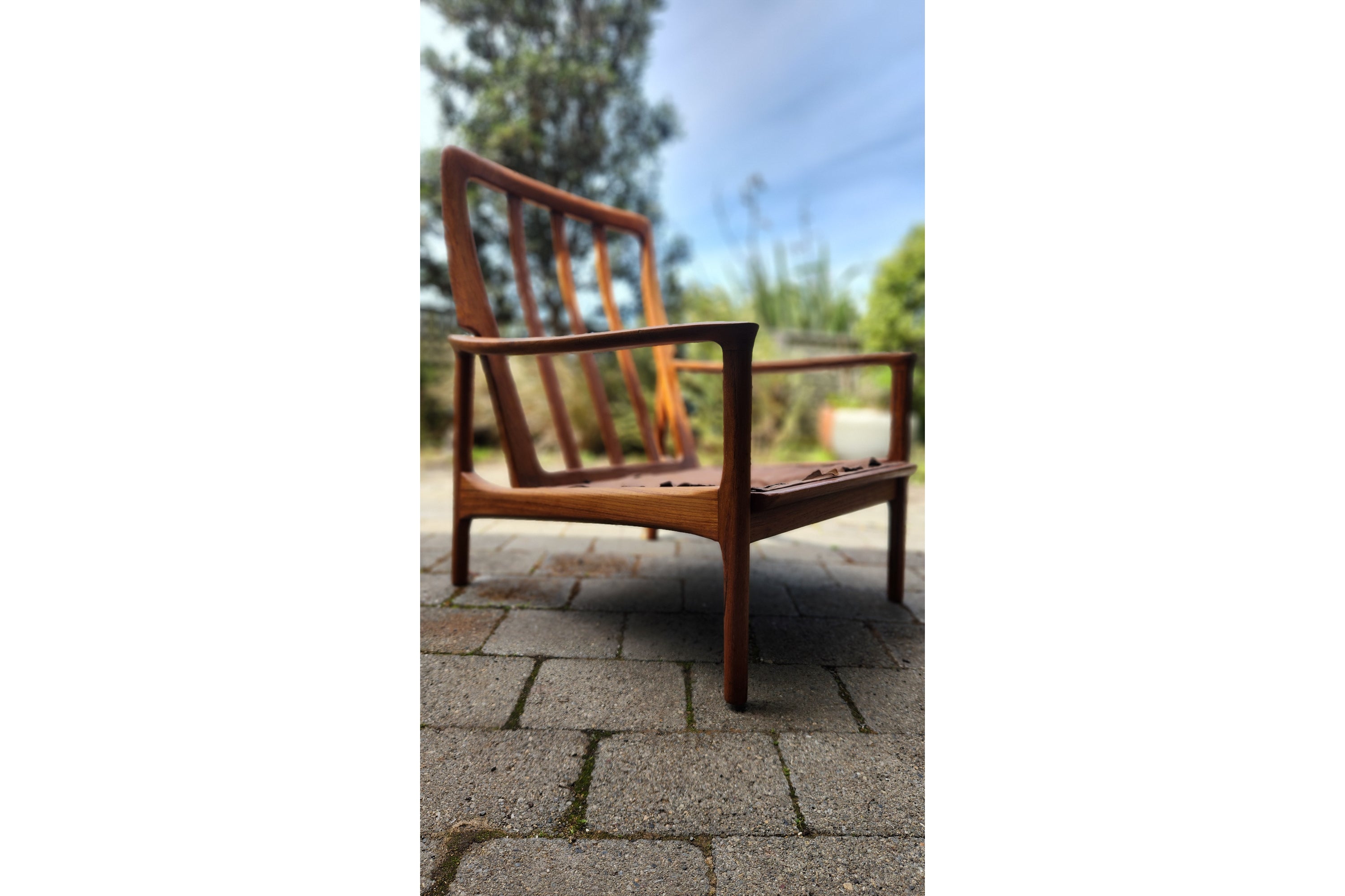 German Mid Century armchair by Mann Mobel in Teak. Seen in sleek profile.
