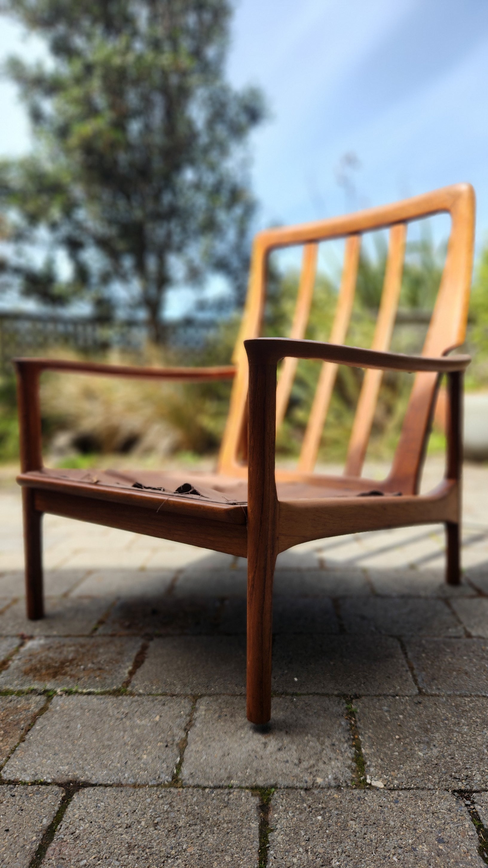 German Mid Century armchair by Mann Mobel in Teak. Seen in sleek profile.