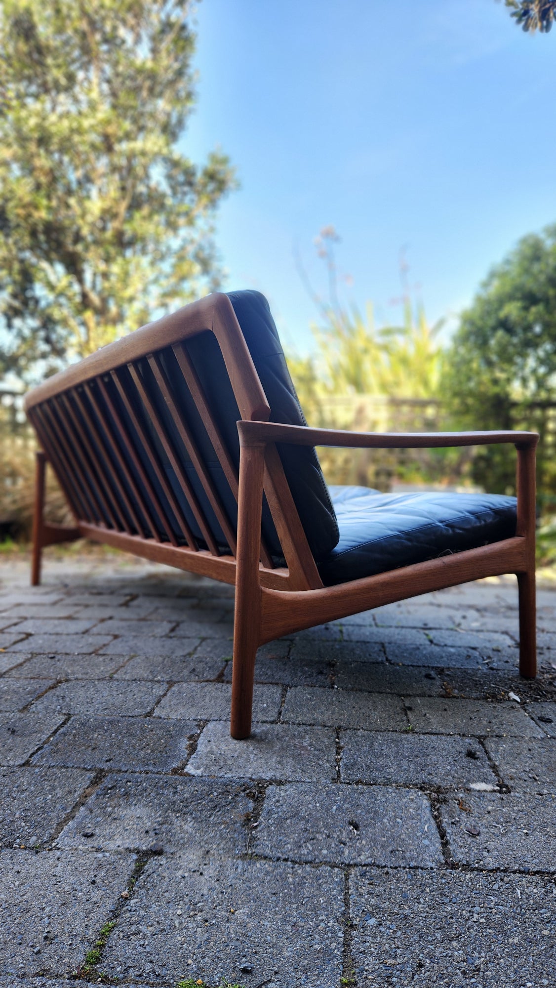 Teak Mid Century sofa by Mann Mobler of West Germany. Seen from rear in profile.