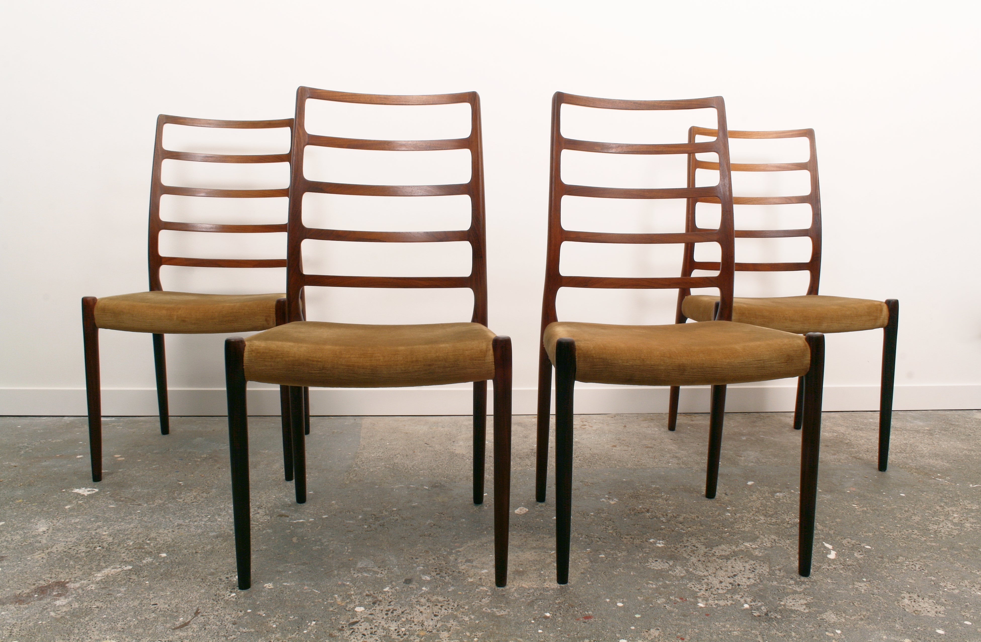 Four Moller Danish chairs facing forwards in pairs.