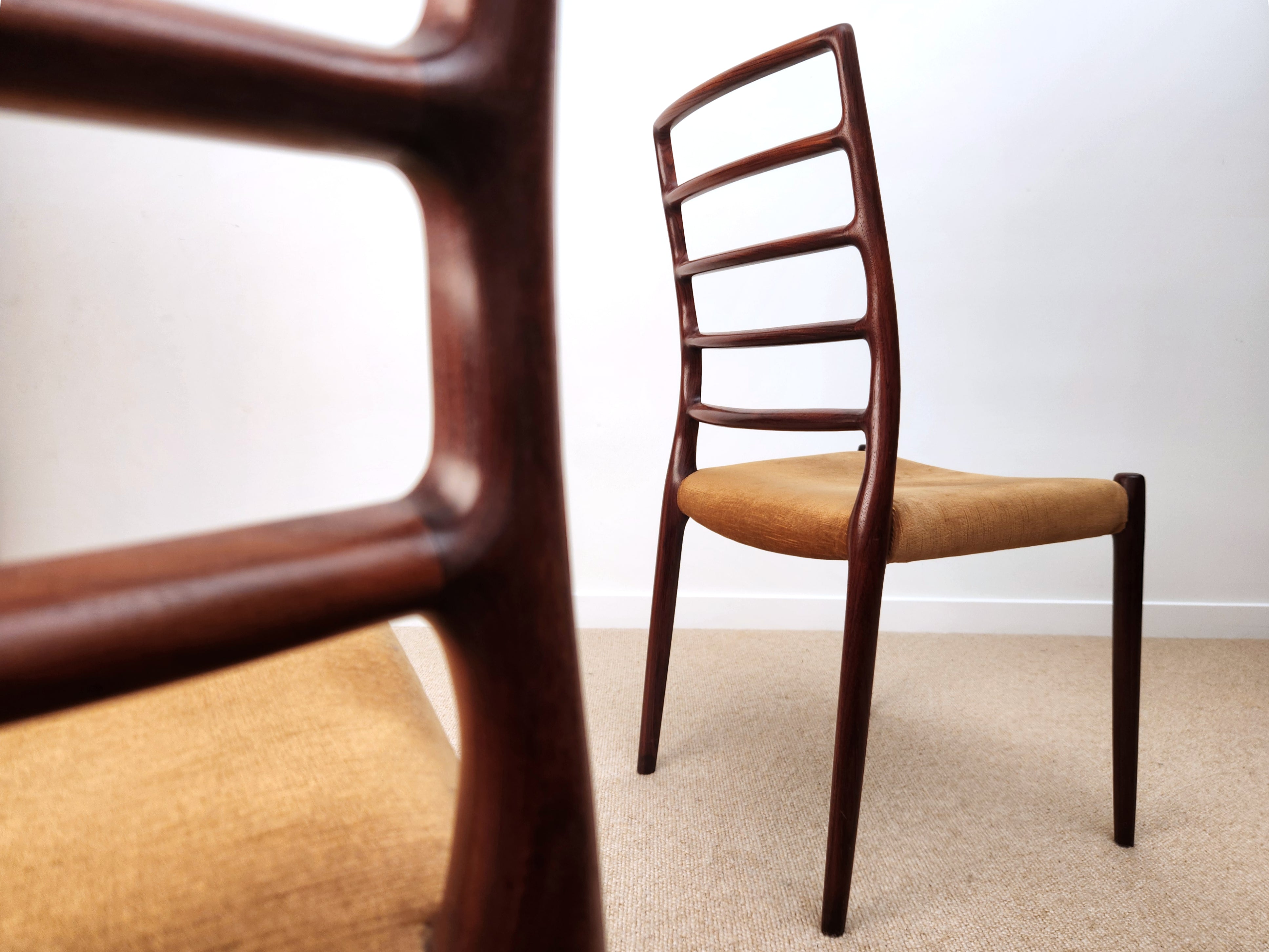 Moller Danish rosewood chairs -  model 82 with sculpted ladderbacks. One chair in focus, with closeup joint detail blurred.